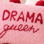 Almofada Drama Queen em Punch Needle com Lã Paratapet — detalhe da escrita em vermelho sobre fundo rosa com pompons