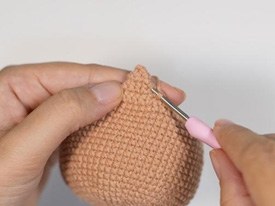 Capinha posicionada na cabeça do amigurumi Cedrico