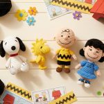 Coleção Kit Amigurumi Peanuts Círculo: Snoopy, Woodstock, Charlie Brown e Lucy em crochê sobre flat lay amarelo com novelos e ganchinho