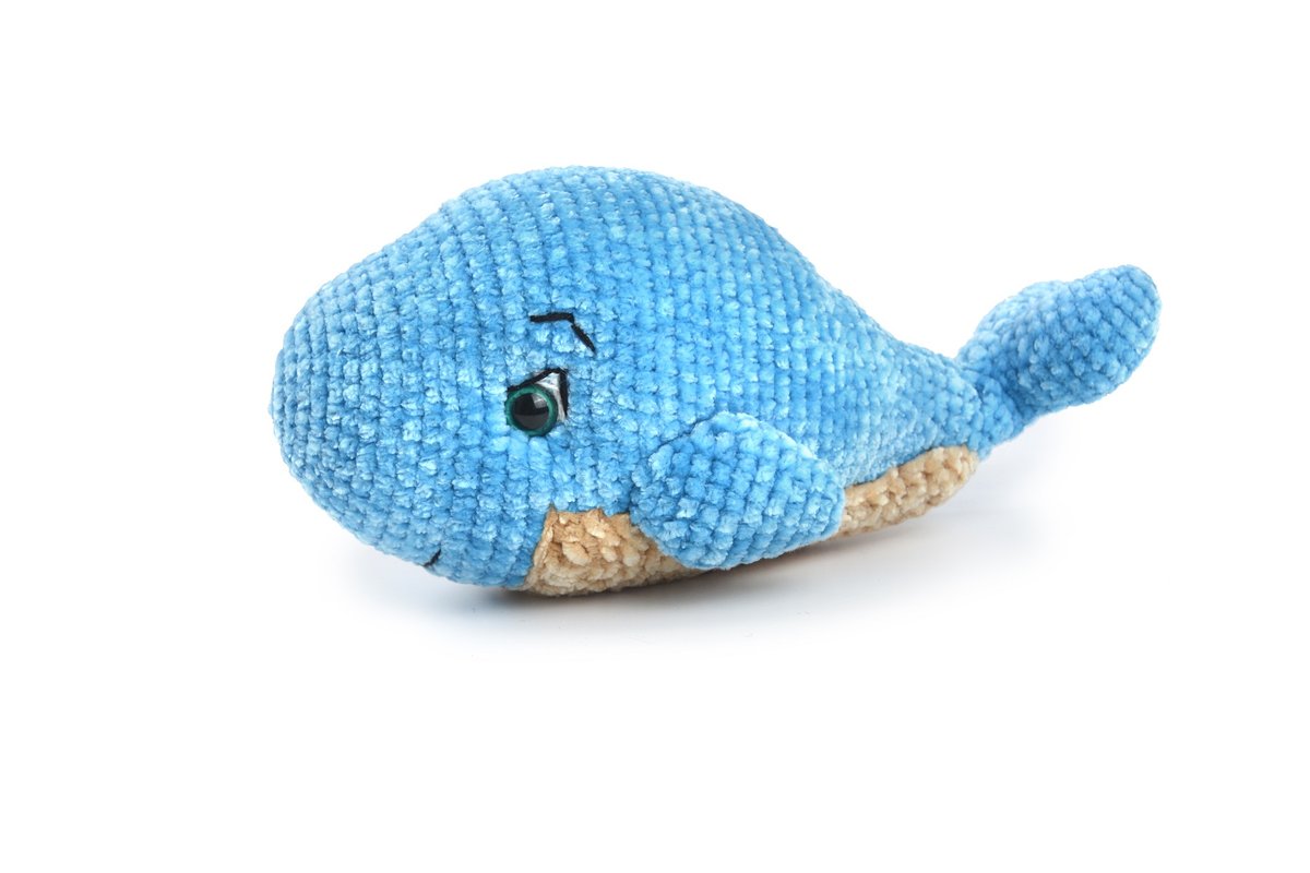 Baleia Pelúcia amigurumi vista lateral mostrando olhos de segurança azuis, sobrancelha bordada e barriga castanha