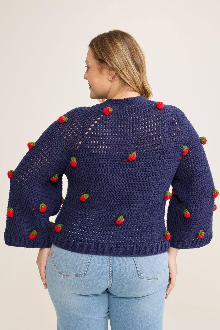 Blusa Berry de crochê vista de costas, mostrando a pala em ponto vazado e morangos aplicados nas costas e mangas