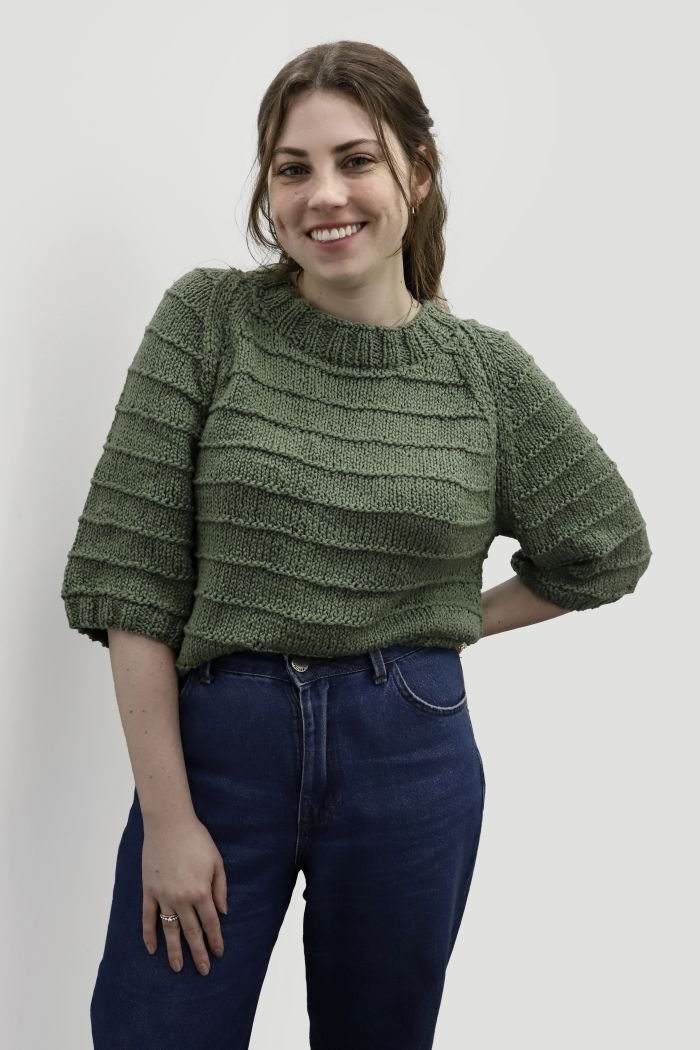 Blusa Miranda de tricô com Linha In Love na cor Militar, modelo vestindo a blusa com jeans