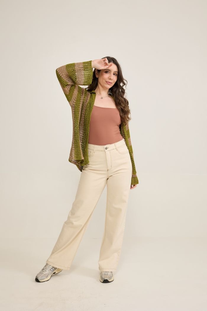 Camisa Nascente de crochê vestida sobre top, look completo com calça clara