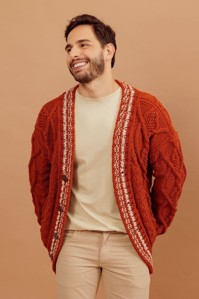 Cardigã masculino de tricô com tranças aberto, vista frontal mostrando detalhes em branco na lapela e botões