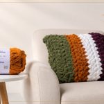 Almofada de crochê com Cisne Hug em listras verde, caramelo, branco e roxo