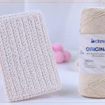 Carteira de crochê feita com Fio Cisne Original ao lado do novelo – Receita de Crochê para o Dia das Mães