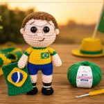Amigurumi Garoto Torcedor do Brasil com camisa amarela, calção azul e óculos, segurando a bandeira, ao lado de novelo do Fio Cisne Amigurumi Perfeito verde