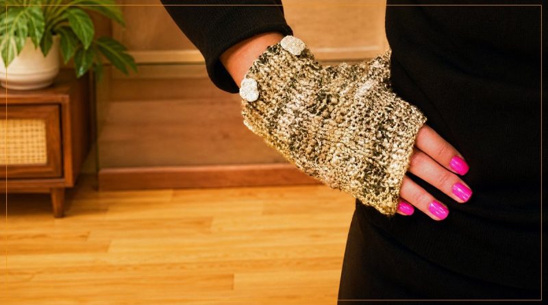 Luva sem dedo em tricô com fio mescla dourado vestida em mão feminina com roupa preta