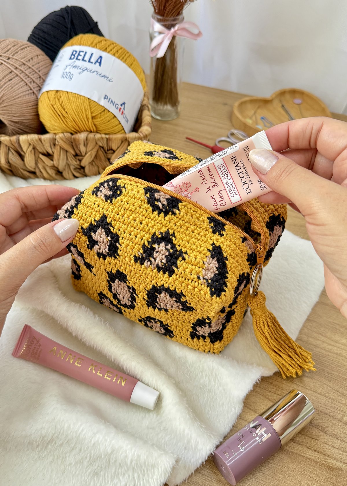 Estojo Onça de crochê aberto com produtos de maquiagem dentro