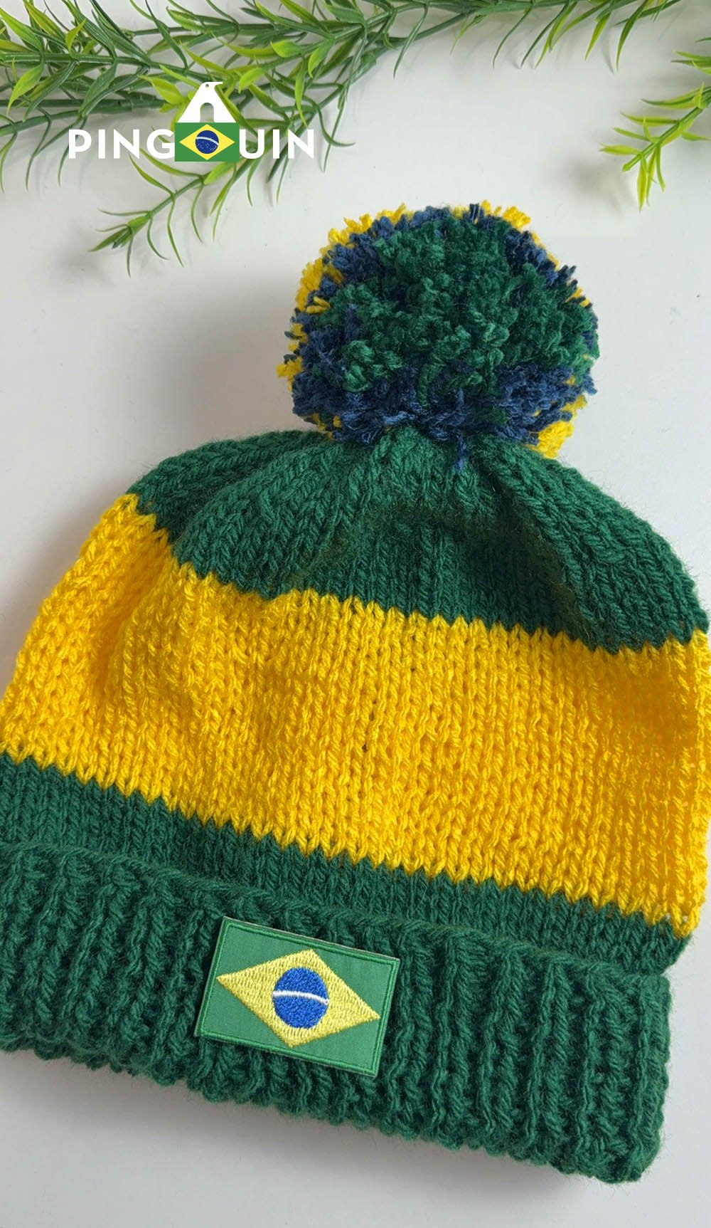 Detalhe do Gorro Copa mostrando os pontos de tricô em verde e amarelo e o pompom tricolor