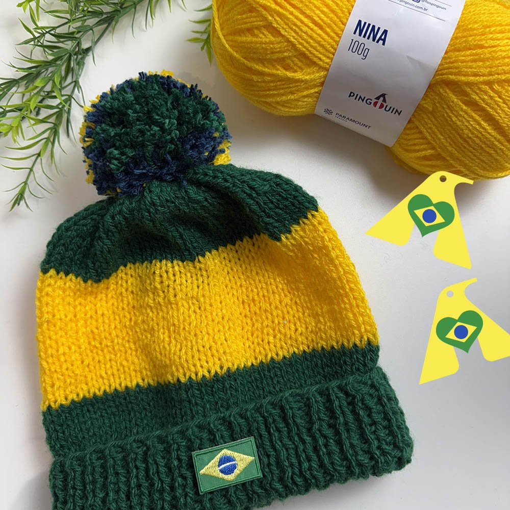 Gorro Copa de tricô nas cores verde e amarelo com pompom tricolor e detalhe da bandeira do Brasil