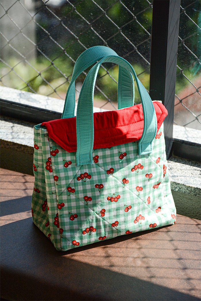 Lancheira de Cerejas em patchwork com tecido xadrez verde e estampa de cerejas, alças tiffany e forro vermelho