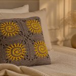 Almofada Solar de Crochê com Barbante Barroco Maxcolor — quatro motivos sol em cinza e amarelo