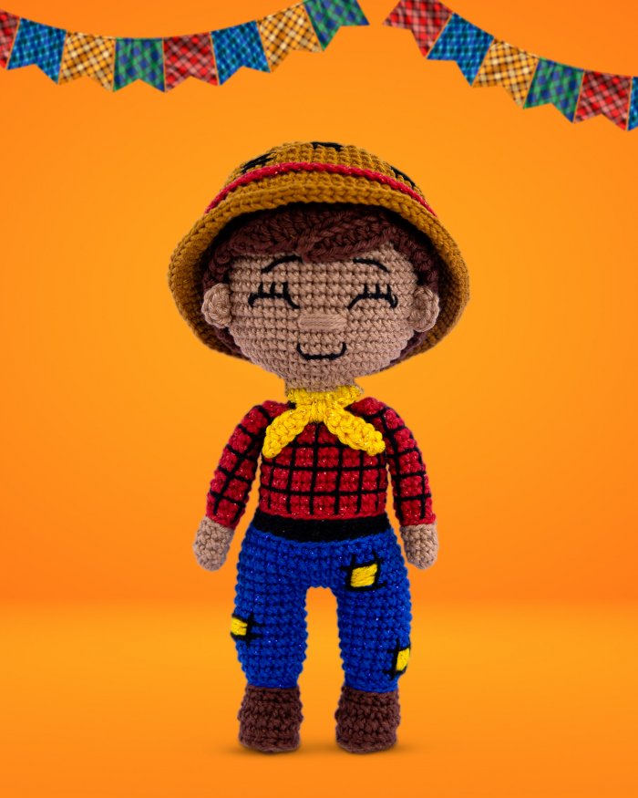Boneco Chico amigurumi de crochê — caipira junino com camisa xadrez vermelha, calça azul com remendos, chapéu de palha e lenço amarelo
