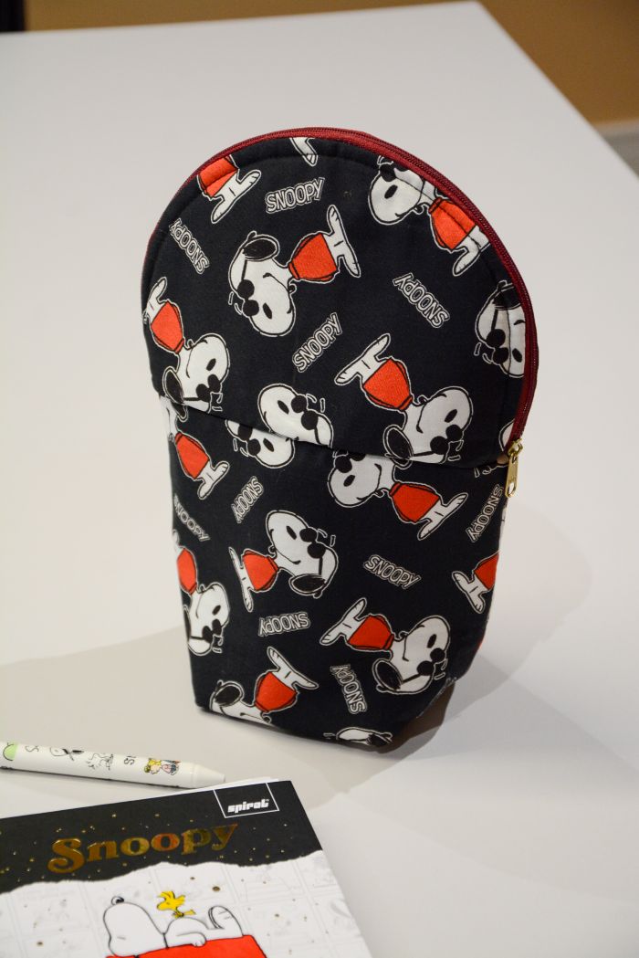 Base do estojo dobrável Snoopy Cool – detalhe das caixas de leite e costura de acabamento