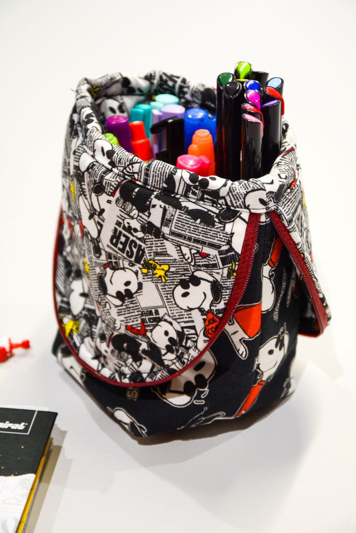 Estojo dobrável Snoopy Cool – detalhe do tecido Peanuts fundo preto com zíper vermelho