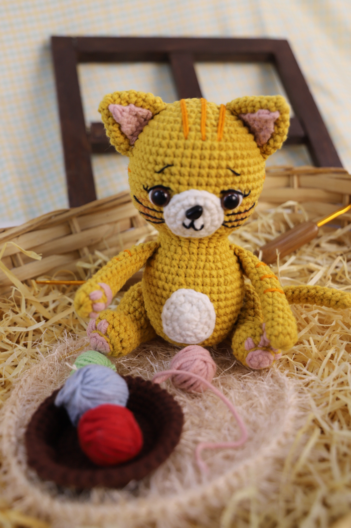 Gatinho Crocheteiro Mostarda de amigurumi – detalhe da face com olhos castanhos, focinho bordado e bigodes