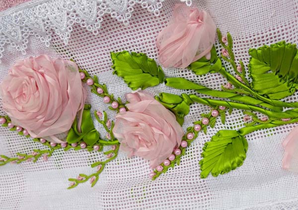Processo de bordado da toalha com rosas de fita — etapa de formação das rosas em fita voal