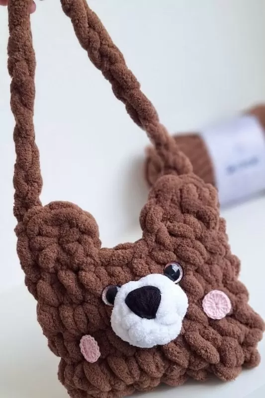 Detalhe da Bolsa Urso de Crochê com Fio Cisne Hug marrom, mostrando focinho branco, nariz bordado, olhos e bochechas rosa