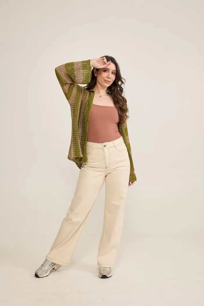 Camisa Nascente de crochê vestida sobre top, look completo com calça clara