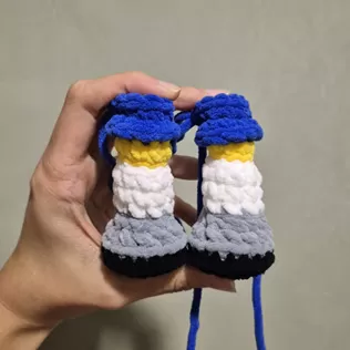 Pernas do Canarinho Pistola amigurumi montadas com shorts azul e chuteiras