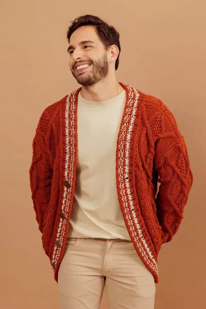 Cardigã masculino de tricô com tranças aberto, vista frontal mostrando detalhes em branco na lapela e botões