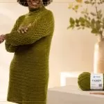 Vestido de crochê verde oliva feito com Fio Cisne Design — modelo com gola alta e mangas em relevo