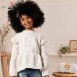 Blusa Fantasia de Tricô Infantil com Fio Baby Pop Círculo — menina sorrindo com blusa com babados