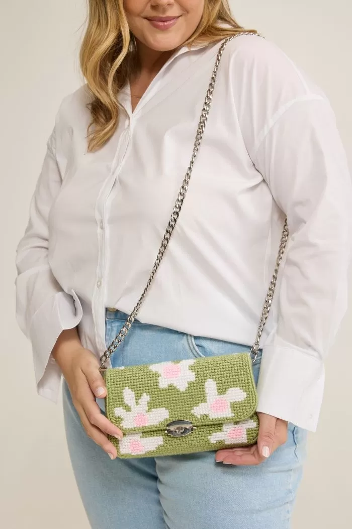 Bolsa Daisy usada a tiracolo com a correntinha metálica sobre look de jeans e camisa branca