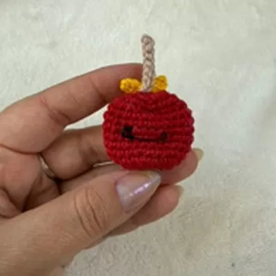 Bóton maçã do amor de crochê finalizado com alfinete