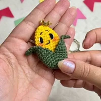 Bóton milho junino com mini coroa dourada — crochê Bella Pingouin