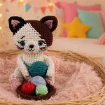 Gatinho Crocheteiro Malhado Amigurumi Soft Círculo — gatinho tricolor sentado em cestinha com novelinhos