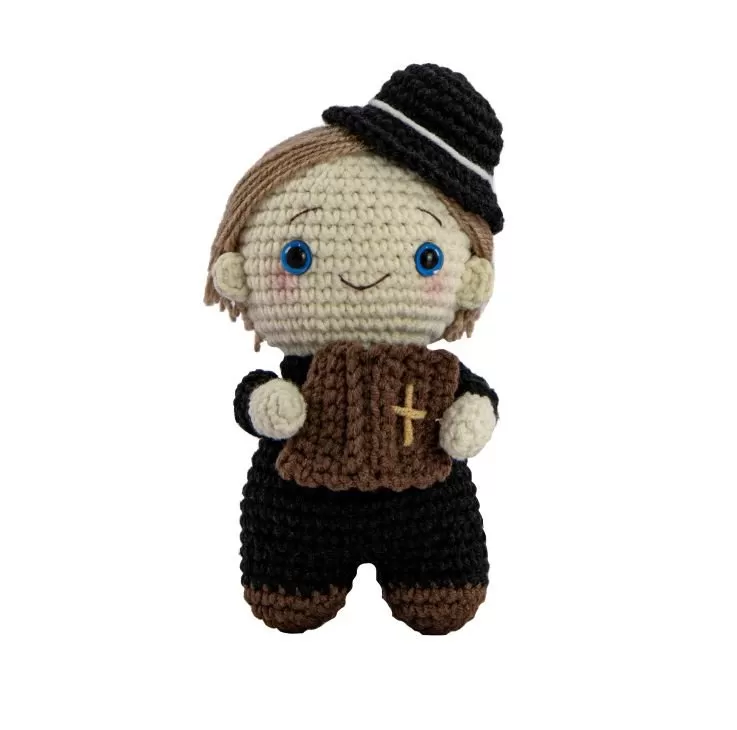 Detalhe da bíblia do Padre Zezinho amigurumi com cruz bordada em gengibre
