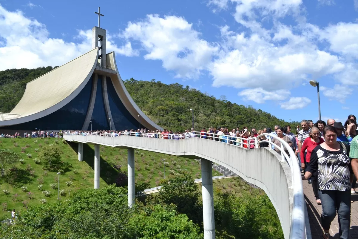 Santuário Santa Paulina em Nova Trento (SC) com fiéis na passarela de acesso e arquitetura em formato de mãos em prece