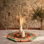 Centro de mesa Piquenique em patchwork octogonal com tecidos xadrez, poás e chocolate sobre mesa de mármore