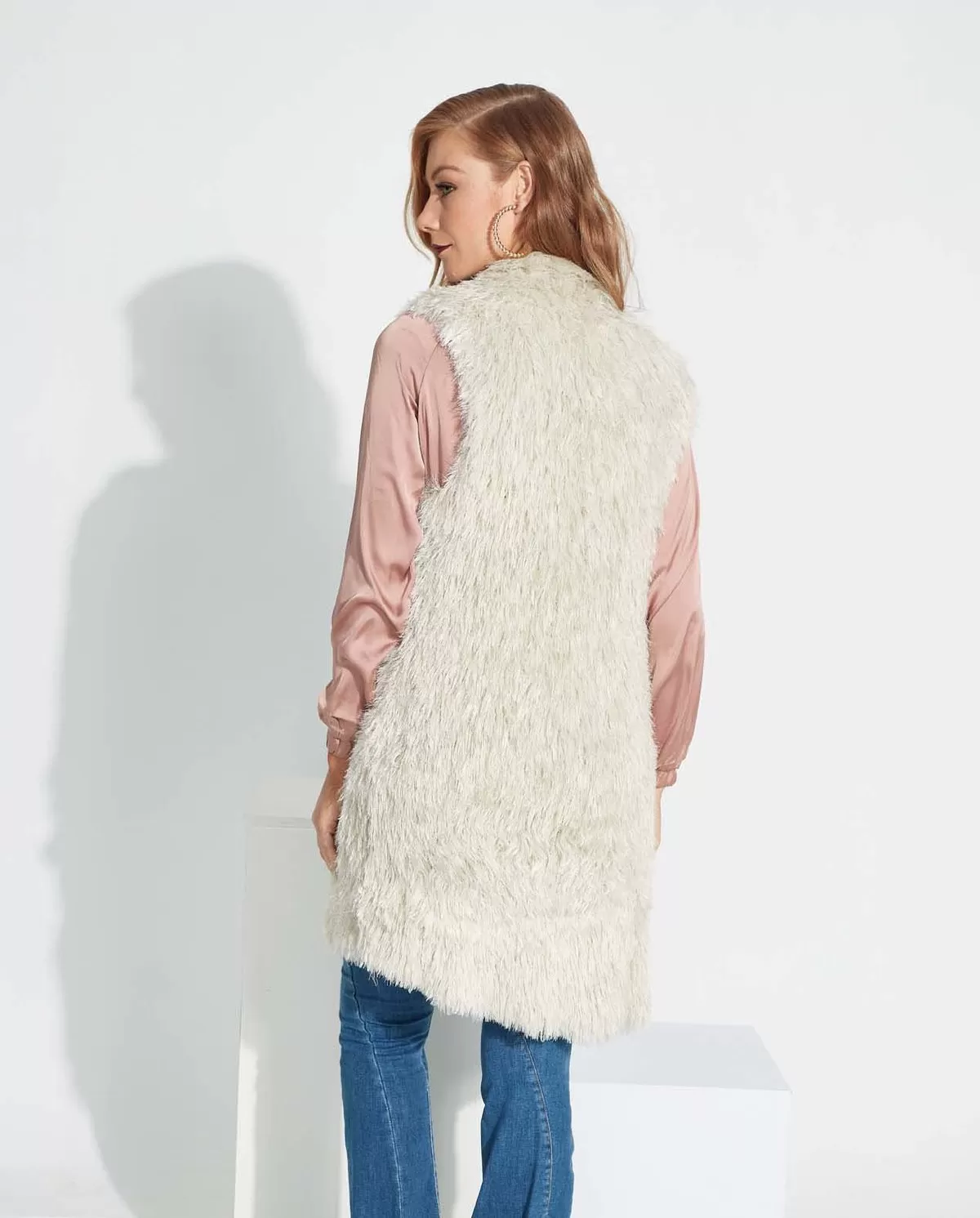 Colete Off longo em Fio Majestoso combinado com blusa rosa e jeans